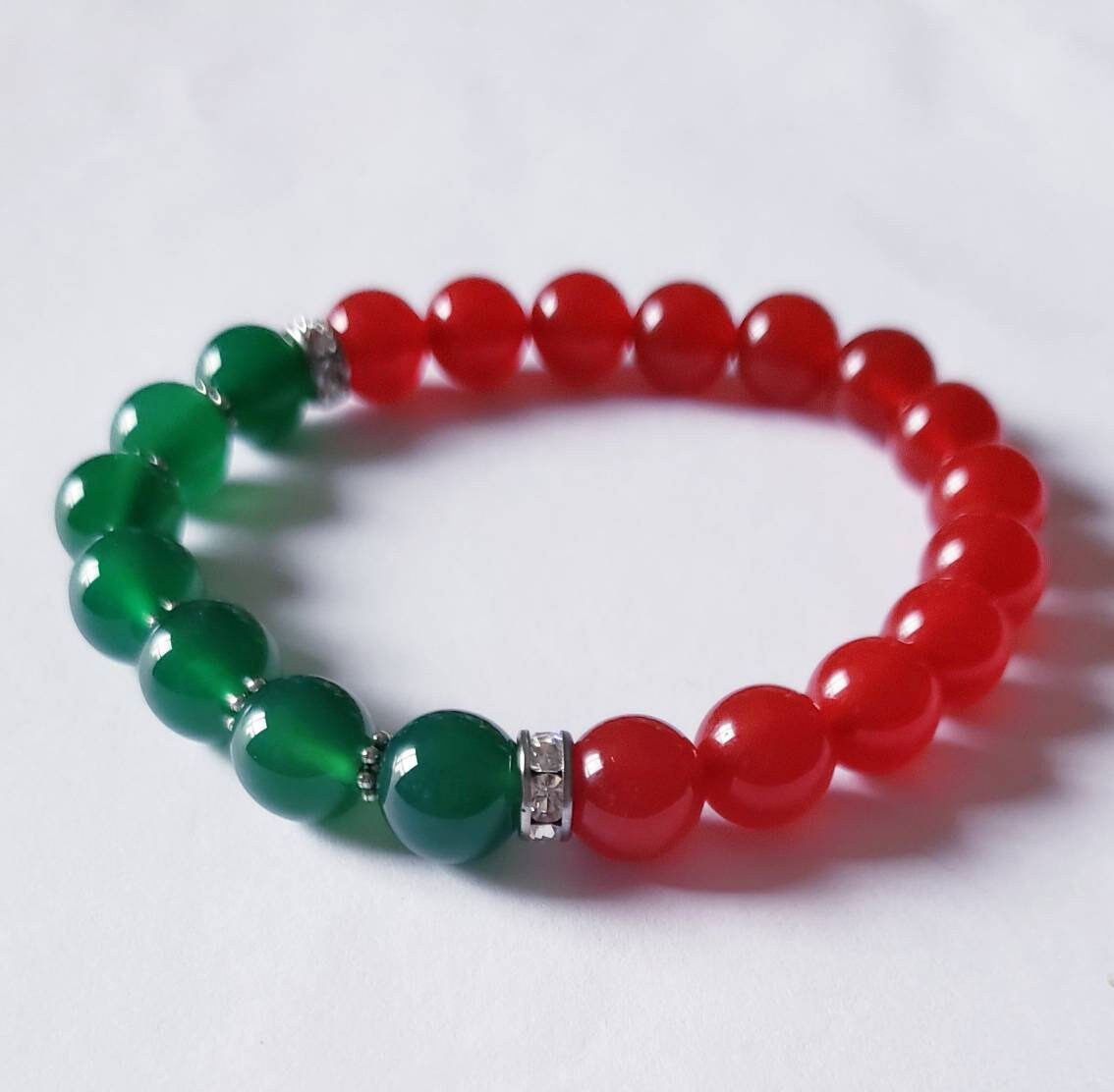 Green and Red Onyx Crystal Bracelet featuring handmade beaded design crafted for both women and men. This lucky charm jewelry combines vibrant green and deep red onyx stones, known for promoting abundance, protection, and positive energy. Perfect as a meaningful gift for him or her, this stylish bracelet blends artisanal craftsmanship with spiritual benefits. Lightweight and versatile, it adds a powerful and elegant touch to everyday wear or special occasions.