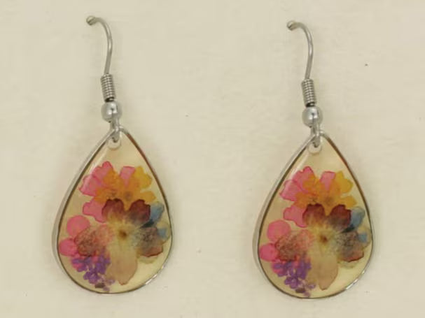 Floral Dried Flower Earrings featuring real dried flowers encased in clear resin teardrop shapes, perfect for summer and boho chic style. These handmade statement earrings capture natural beauty in a lightweight, elegant design ideal for women who love nature-inspired jewelry. A thoughtful gift for birthdays, weddings, or festivals, these unique earrings add a soft, romantic touch to any outfit with their delicate floral charm and artisan craftsmanship.