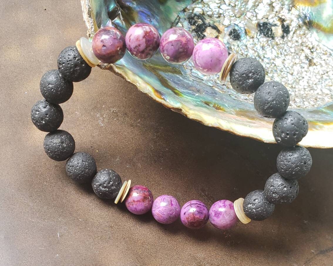 Handmade aromatherapy diffuser bracelet featuring natural purple agate and black lava stones, designed for men and women seeking healing crystal jewelry. This stylish bracelet combines the calming properties of agate with porous lava beads perfect for essential oils, offering both wellness benefits and a fashionable accessory. Ideal as an anniversary gift, this unisex bracelet blends holistic healing with modern handcrafted design.