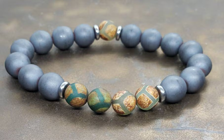 Gray Hematite Bracelet featuring Tibetan Agate accents, handcrafted as a crystal healing jewelry piece for men. This lucky charm bracelet combines the grounding energy of hematite with the protective properties of Tibetan agate, promoting balance and spiritual wellness. Lightweight and stylish, it makes a meaningful gift for him, perfect for everyday wear or meditation. Unique Tibetan-inspired design blends artisanal craftsmanship with natural healing stones.