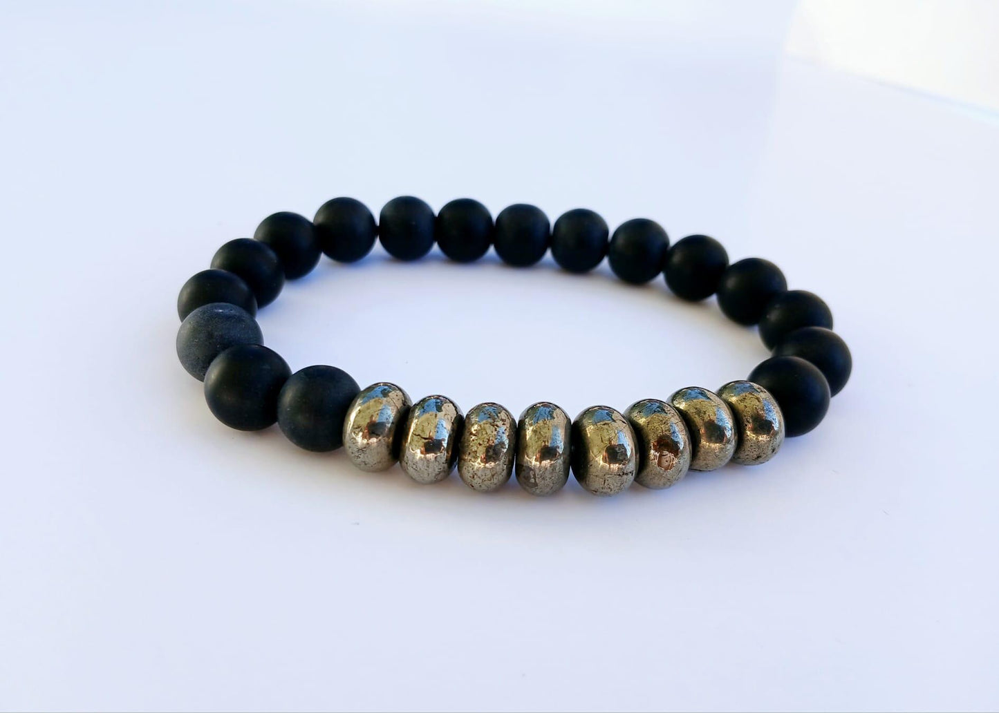 Black Onyx and Pyrite Bracelet featuring handmade beaded natural stones crafted into a crystal healing jewelry piece for men and women. This spiritual bracelet combines the grounding energy of black onyx with the protective power of pyrite, promoting balance and positive energy. Lightweight and stylish, it makes a meaningful gift for him or her. Perfect for everyday wear, meditation, or as a unique accessory blending artisanal craftsmanship with natural healing properties.