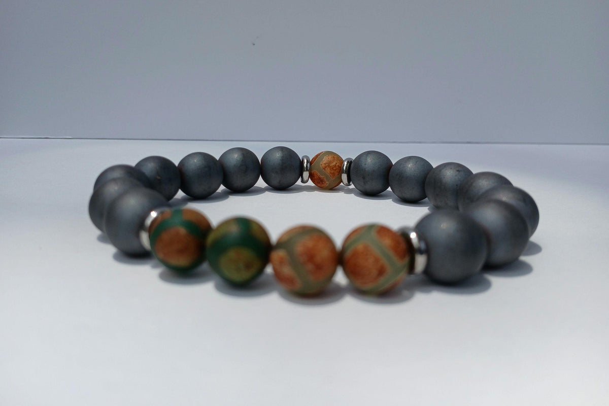 Gray Hematite Bracelet featuring Tibetan Agate accents, handcrafted as a crystal healing jewelry piece for men. This lucky charm bracelet combines the grounding energy of hematite with the protective properties of Tibetan agate, promoting balance and spiritual wellness. Lightweight and stylish, it makes a meaningful gift for him, perfect for everyday wear or meditation. Unique Tibetan-inspired design blends artisanal craftsmanship with natural healing stones.
