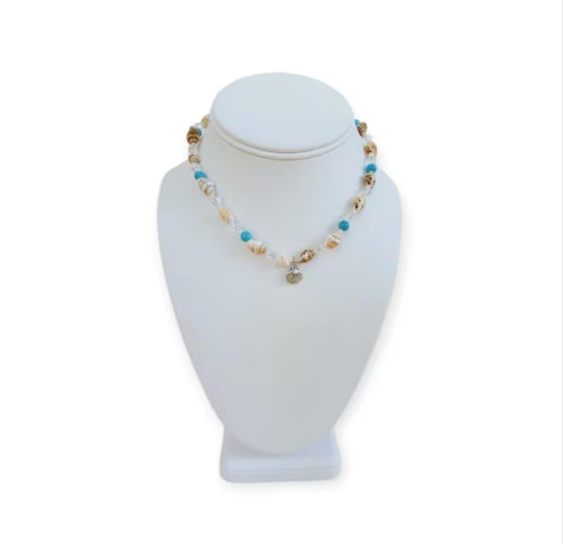 Beige Seashell and Turquoise Choker handcrafted with natural shells and vibrant turquoise beads for a beach-inspired, boho-chic look. This handmade necklace adds a coastal, summery touch to any outfit, perfect for casual wear, vacations, or seaside adventures. Ideal as a thoughtful gift for women who love beach jewelry, handmade accessories, or unique statement pieces that combine natural materials, artisanal craftsmanship, and effortless coastal style.