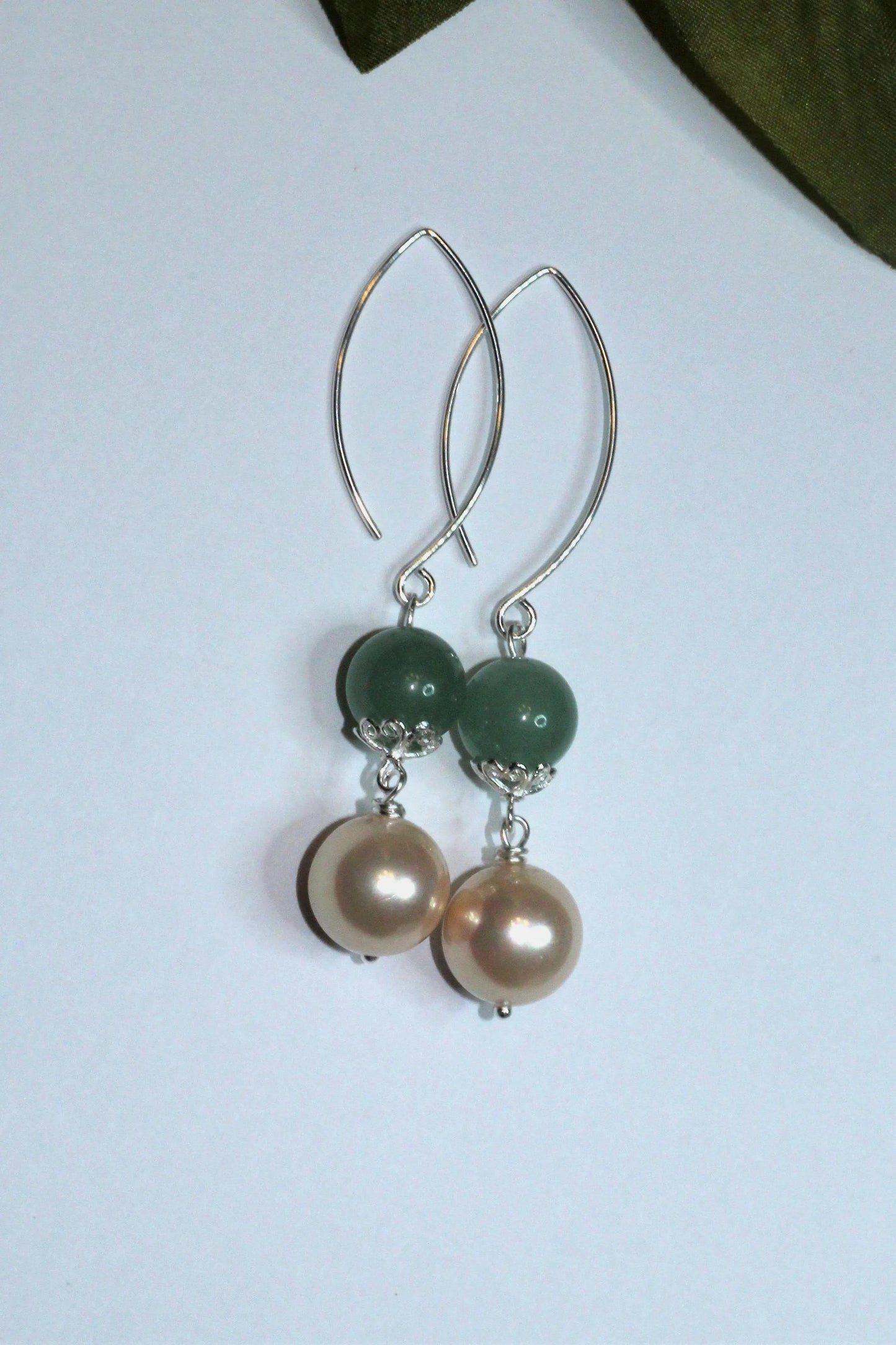 Green Aventurine Earrings with Freshwater Pearl Dangles handcrafted in sterling silver for an elegant, timeless look. These earrings feature natural green aventurine stones paired with lustrous freshwater pearls, symbolizing luck, prosperity, and calm energy. Perfect for adding a touch of sophistication to any outfit, they make a thoughtful gift for women who appreciate handmade gemstone jewelry, natural healing crystals, and classic accessories that blend beauty with spiritual balance.
