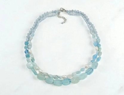 Elegant Aquamarine Necklace featuring natural aquamarine gemstones paired with lustrous freshwater pearls and secured with a sterling silver clasp. This handcrafted jewelry piece combines calming blue tones with classic pearl elegance, creating a versatile accessory for everyday wear or special occasions. Perfect as a thoughtful gift for her, this necklace embodies sophistication, serenity, and artisanal craftsmanship, making it ideal for birthdays, anniversaries, or meaningful celebrations.