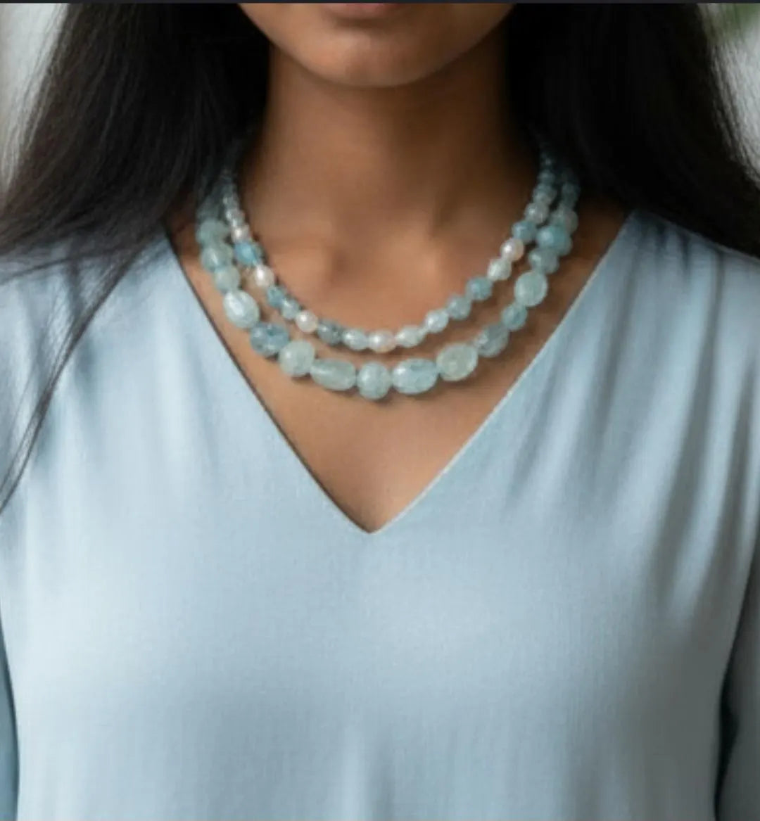Elegant Aquamarine Necklace featuring natural aquamarine gemstones paired with lustrous freshwater pearls and secured with a sterling silver clasp. This handcrafted jewelry piece combines calming blue tones with classic pearl elegance, creating a versatile accessory for everyday wear or special occasions. Perfect as a thoughtful gift for her, this necklace embodies sophistication, serenity, and artisanal craftsmanship, making it ideal for birthdays, anniversaries, or meaningful celebrations.