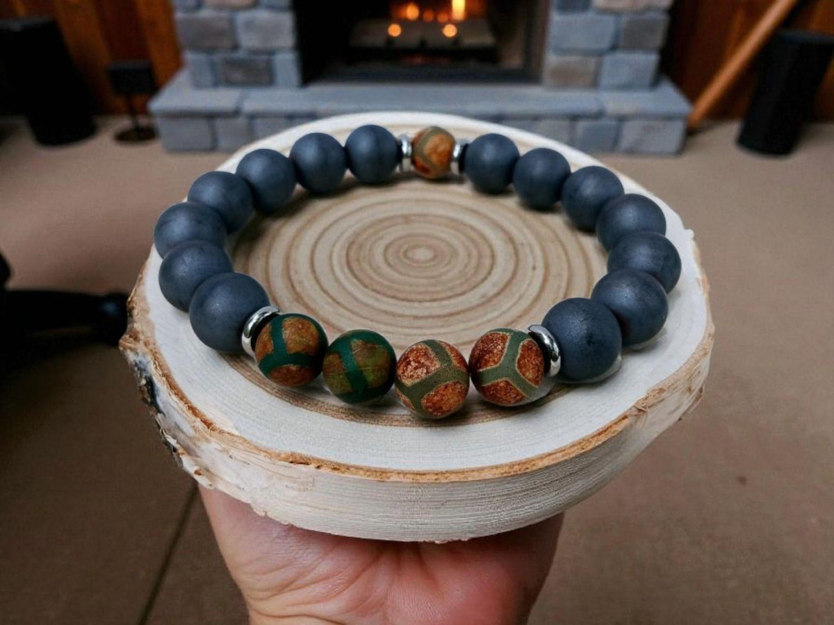 Gray Hematite Bracelet featuring Tibetan Agate accents, handcrafted as a crystal healing jewelry piece for men. This lucky charm bracelet combines the grounding energy of hematite with the protective properties of Tibetan agate, promoting balance and spiritual wellness. Lightweight and stylish, it makes a meaningful gift for him, perfect for everyday wear or meditation. Unique Tibetan-inspired design blends artisanal craftsmanship with natural healing stones.