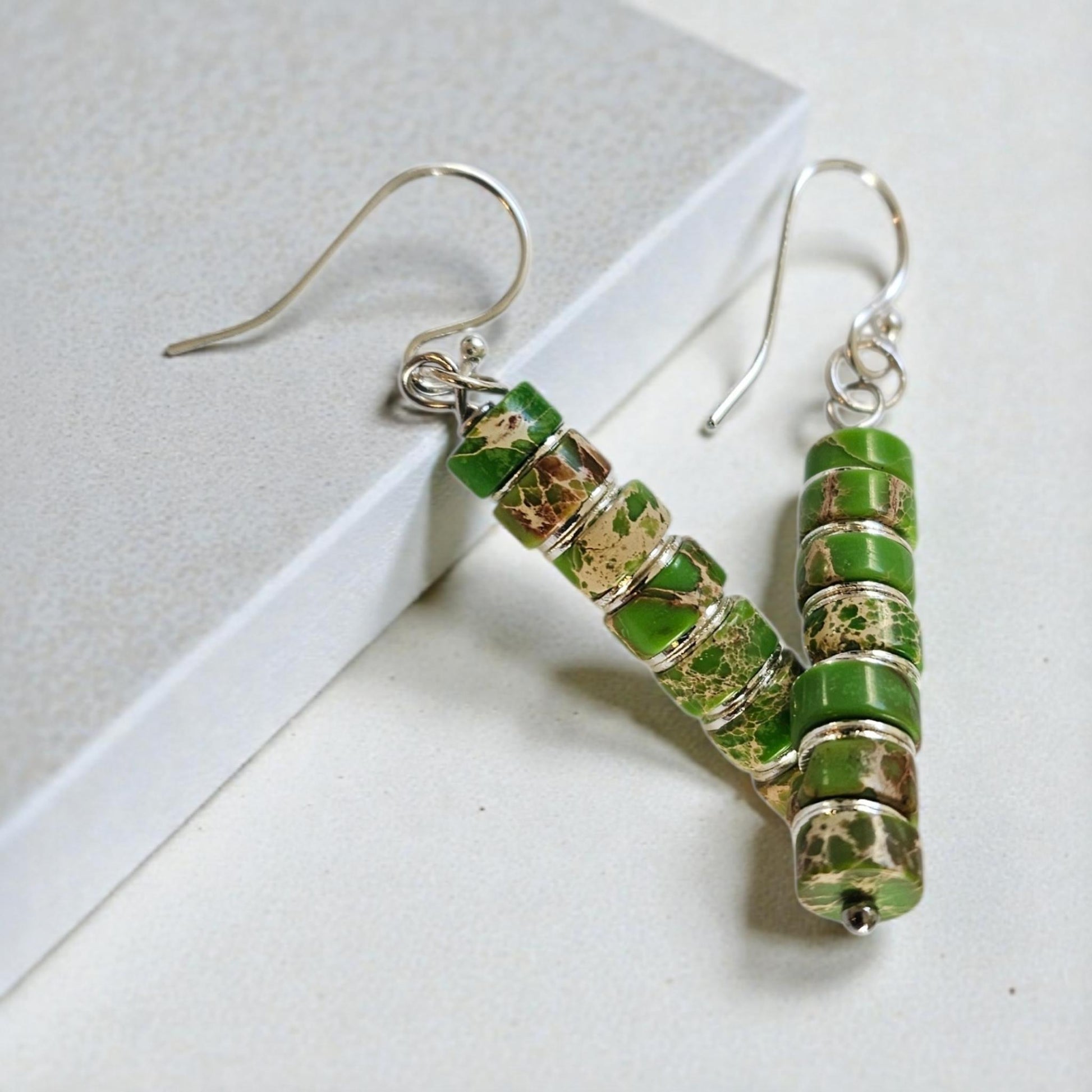 Green Jasper Dangle Earrings featuring natural green jasper stones set in sterling silver, handcrafted in a boho southwestern-inspired design. These elegant earrings showcase earthy tones and artisanal detail, perfect for adding a stylish, versatile touch to casual or festival outfits. Ideal as a thoughtful gift for women who appreciate handmade gemstone jewelry, bohemian fashion, and unique statement accessories that combine natural beauty, spiritual energy, and timeless artisan craftsmanship.