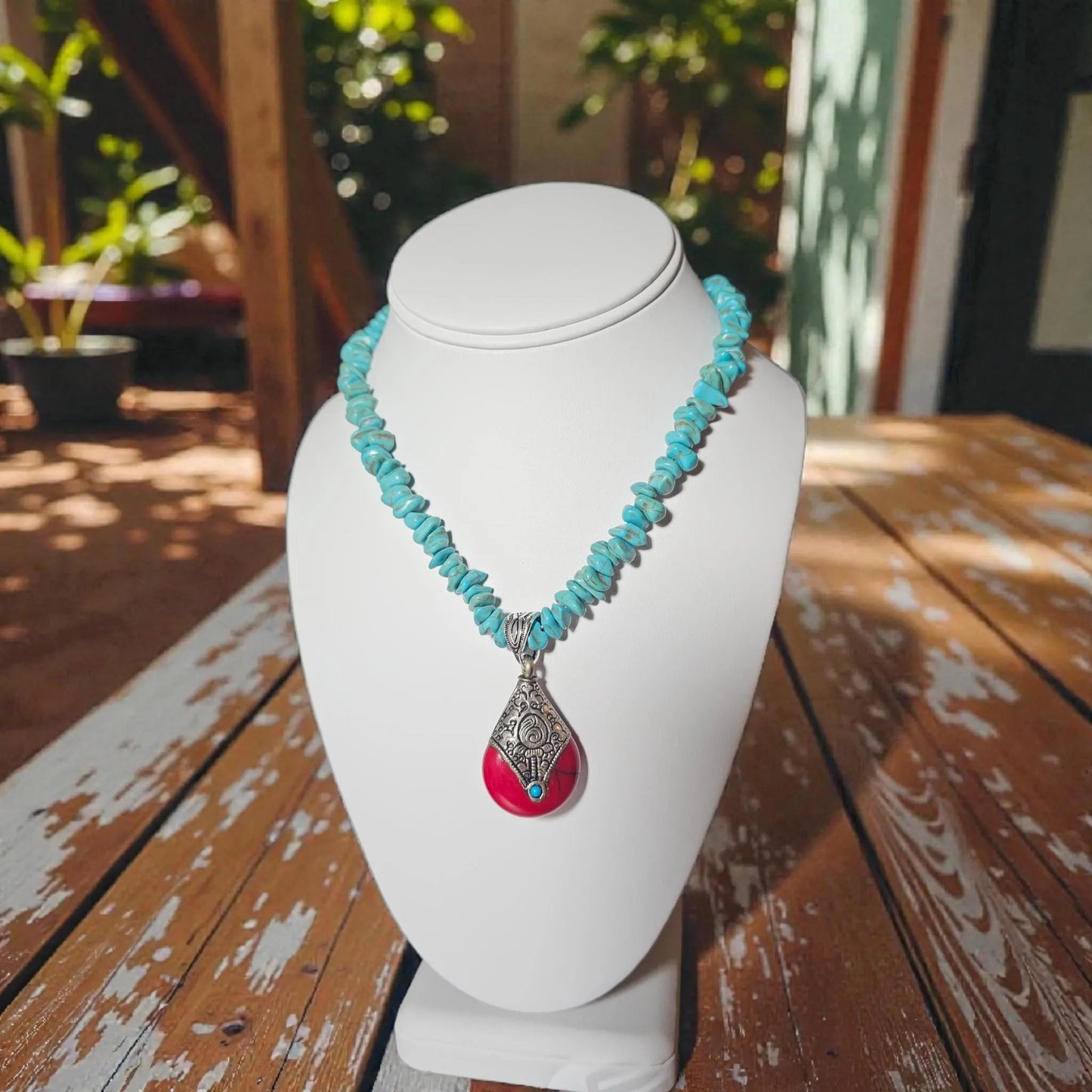 Turquoise Necklace featuring a handmade Tibetan red crackle silver pendant crafted with contemporary repoussé techniques. This unique necklace combines vibrant turquoise stones with intricate artisan metalwork for a bold, statement accessory. Perfect for everyday wear, boho-chic outfits, or special occasions, it makes a thoughtful gift for women who appreciate handcrafted jewelry, cultural designs, and one-of-a-kind pieces that blend color, texture, and artistic craftsmanship.