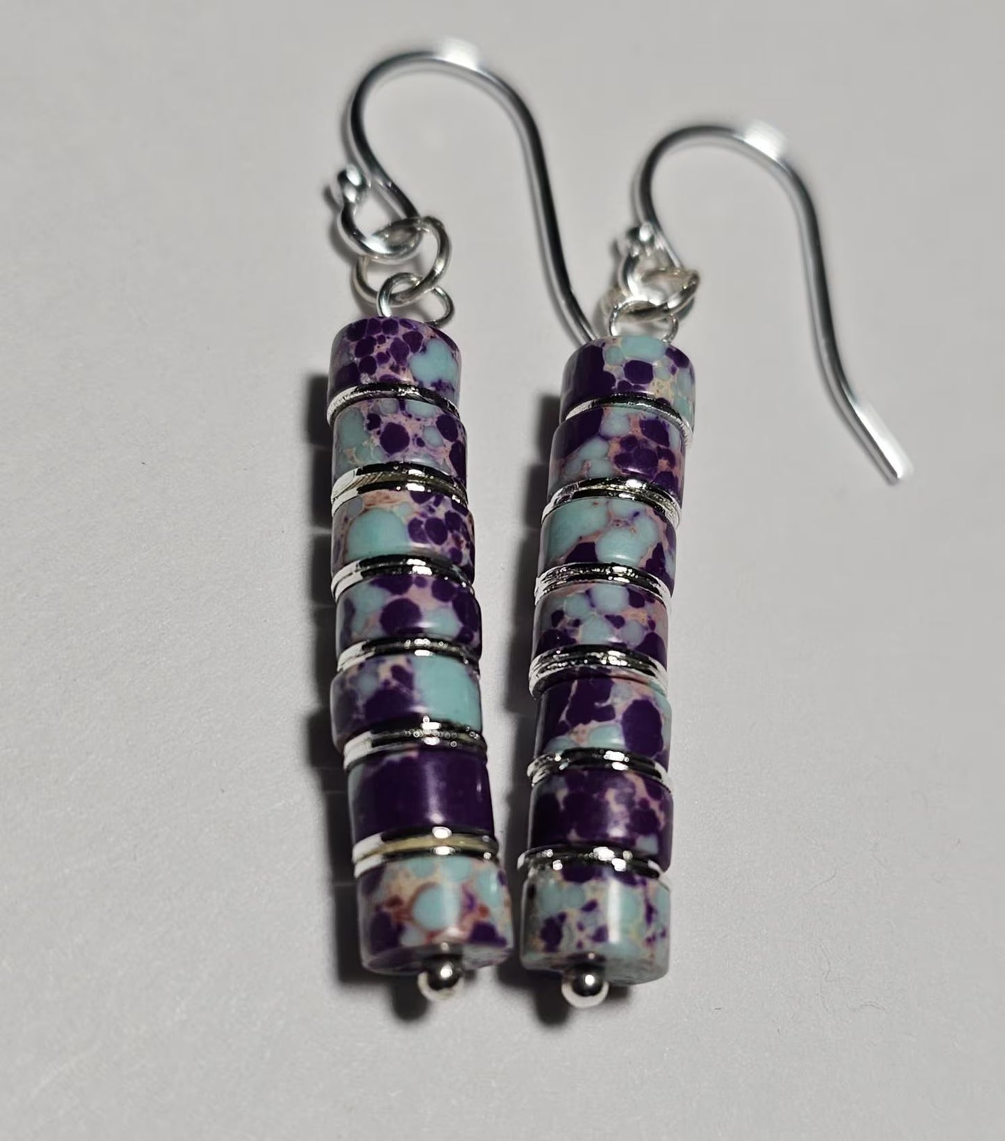 Purple jasper dangle earrings crafted with natural jasper stones and sterling silver hooks, featuring rich purple tones and earthy patterns. These boho southwestern style earrings are handmade to highlight the unique character of each stone, creating a lightweight yet eye-catching accessory. Perfect for everyday wear or special occasions, they make a thoughtful gift for women who love artisan jewelry, natural gemstones, and bohemian or southwestern inspired fashion.