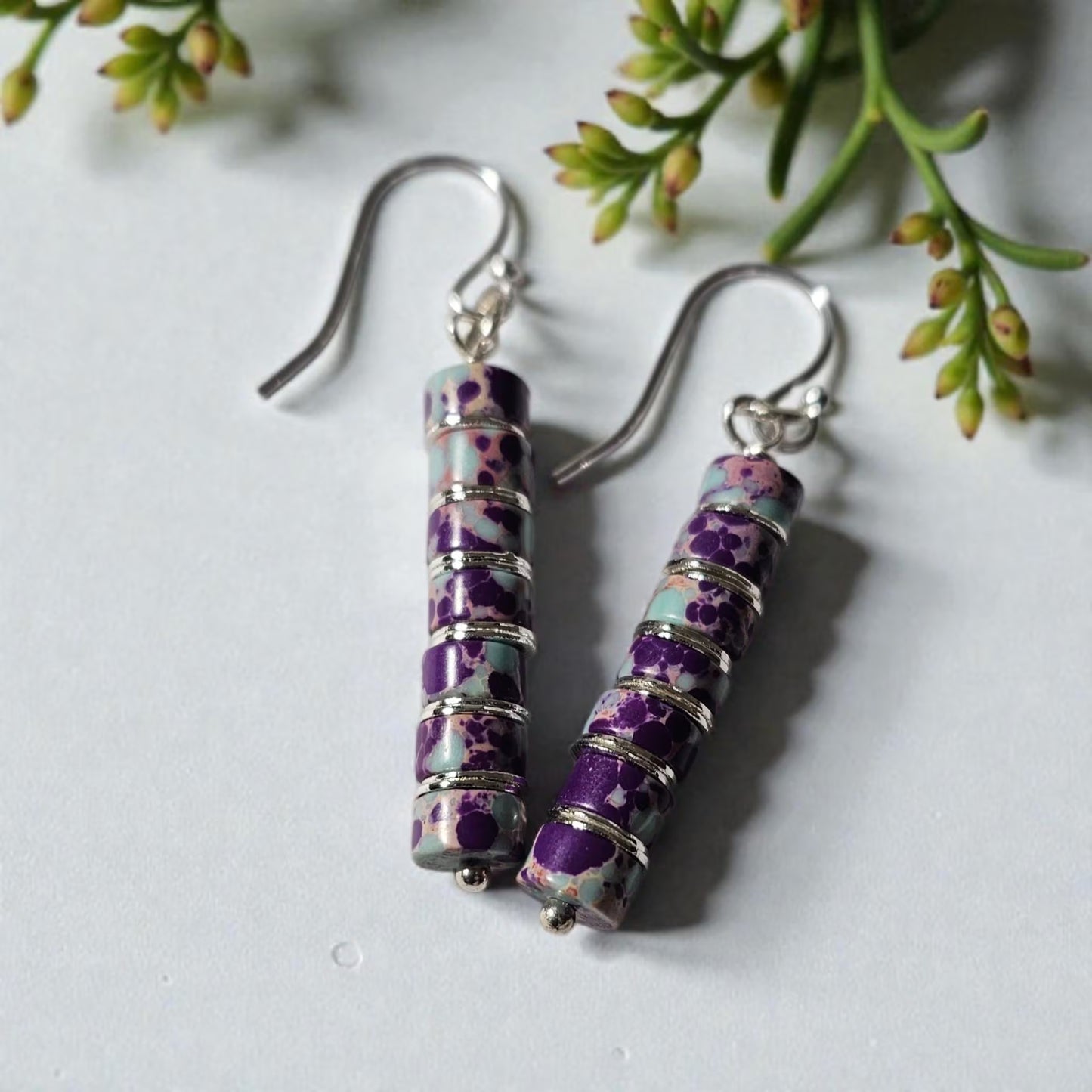 Purple jasper dangle earrings crafted with natural jasper stones and sterling silver hooks, featuring rich purple tones and earthy patterns. These boho southwestern style earrings are handmade to highlight the unique character of each stone, creating a lightweight yet eye-catching accessory. Perfect for everyday wear or special occasions, they make a thoughtful gift for women who love artisan jewelry, natural gemstones, and bohemian or southwestern inspired fashion.