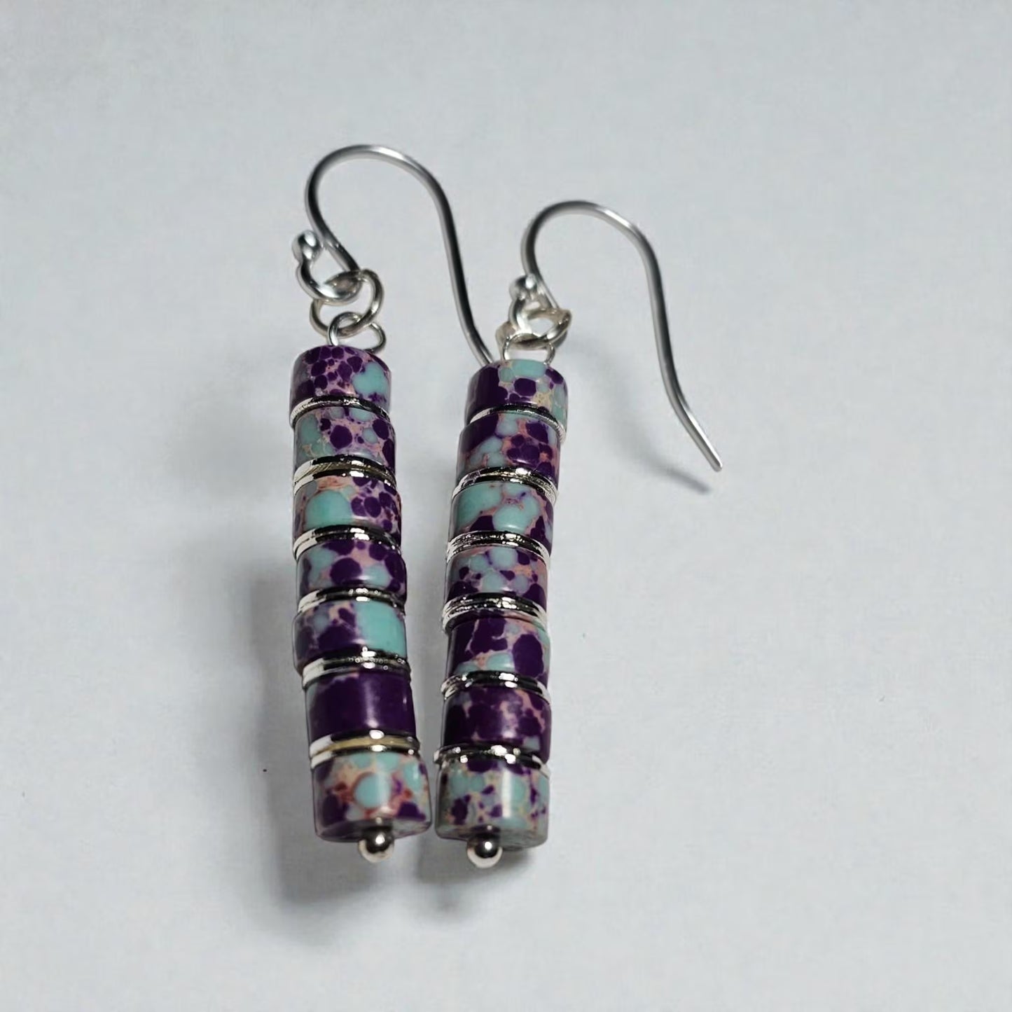 Purple jasper dangle earrings crafted with natural jasper stones and sterling silver hooks, featuring rich purple tones and earthy patterns. These boho southwestern style earrings are handmade to highlight the unique character of each stone, creating a lightweight yet eye-catching accessory. Perfect for everyday wear or special occasions, they make a thoughtful gift for women who love artisan jewelry, natural gemstones, and bohemian or southwestern inspired fashion.