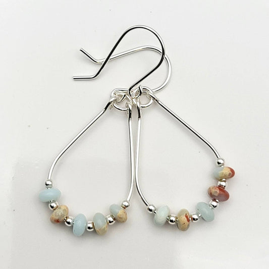 Light Blue Jasper Sterling Silver Earrings featuring handmade amazonite teardrop hoops designed for women who love elegant, natural blue jewelry. These artisanal earrings blend soothing jasper and amazonite stones with sterling silver craftsmanship, creating a delicate yet eye-catching accessory. Perfect as a gift for her or a bridesmaid gift, they add a calming, stylish touch to any outfit, ideal for everyday wear or special occasions with a boho-chic flair.