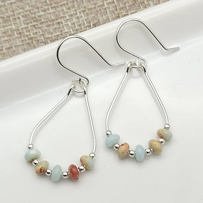 Light Blue Jasper Sterling Silver Earrings featuring handmade amazonite teardrop hoops designed for women who love elegant, natural blue jewelry. These artisanal earrings blend soothing jasper and amazonite stones with sterling silver craftsmanship, creating a delicate yet eye-catching accessory. Perfect as a gift for her or a bridesmaid gift, they add a calming, stylish touch to any outfit, ideal for everyday wear or special occasions with a boho-chic flair.