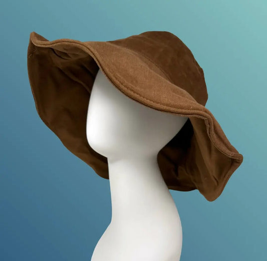 Summer linen bucket hat made from lightweight, breathable hemp fabric for all-day comfort and sun protection. This wide brim brown hat features a soft texture and boho chic style, perfect for women seeking a stylish yet functional accessory for the beach, travel, or daily wear. Designed to shield from harmful UV rays while complementing casual and bohemian outfits. Stay cool, protected, and fashionable this summer.