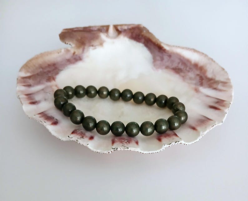 Good Luck Pyrite Bracelet featuring handmade crystal beads designed to attract abundance and positive spiritual energy. This unisex bracelet combines shimmering pyrite stones with artisanal craftsmanship, making it a meaningful gift for both women and men. Lightweight and stylish, it promotes confidence, prosperity, and protection. Perfect for everyday wear or meditation, this abundance bracelet blends healing properties with modern boho jewelry aesthetics.