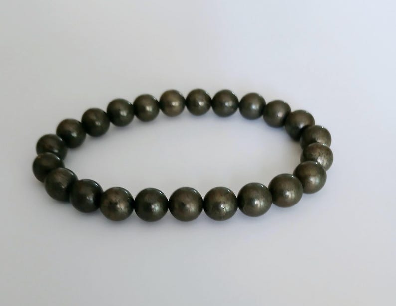 Good Luck Pyrite Bracelet featuring handmade crystal beads designed to attract abundance and positive spiritual energy. This unisex bracelet combines shimmering pyrite stones with artisanal craftsmanship, making it a meaningful gift for both women and men. Lightweight and stylish, it promotes confidence, prosperity, and protection. Perfect for everyday wear or meditation, this abundance bracelet blends healing properties with modern boho jewelry aesthetics.