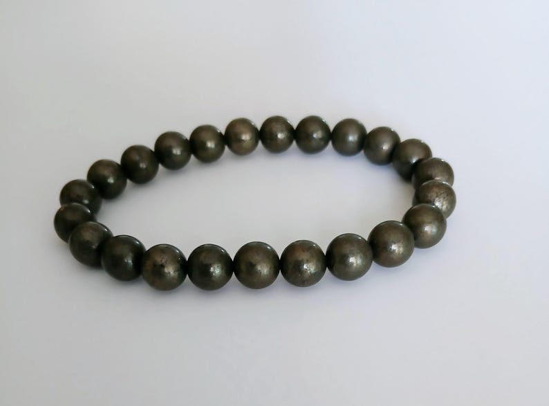 Good Luck Pyrite Bracelet featuring handmade crystal beads designed to attract abundance and positive spiritual energy. This unisex bracelet combines shimmering pyrite stones with artisanal craftsmanship, making it a meaningful gift for both women and men. Lightweight and stylish, it promotes confidence, prosperity, and protection. Perfect for everyday wear or meditation, this abundance bracelet blends healing properties with modern boho jewelry aesthetics.