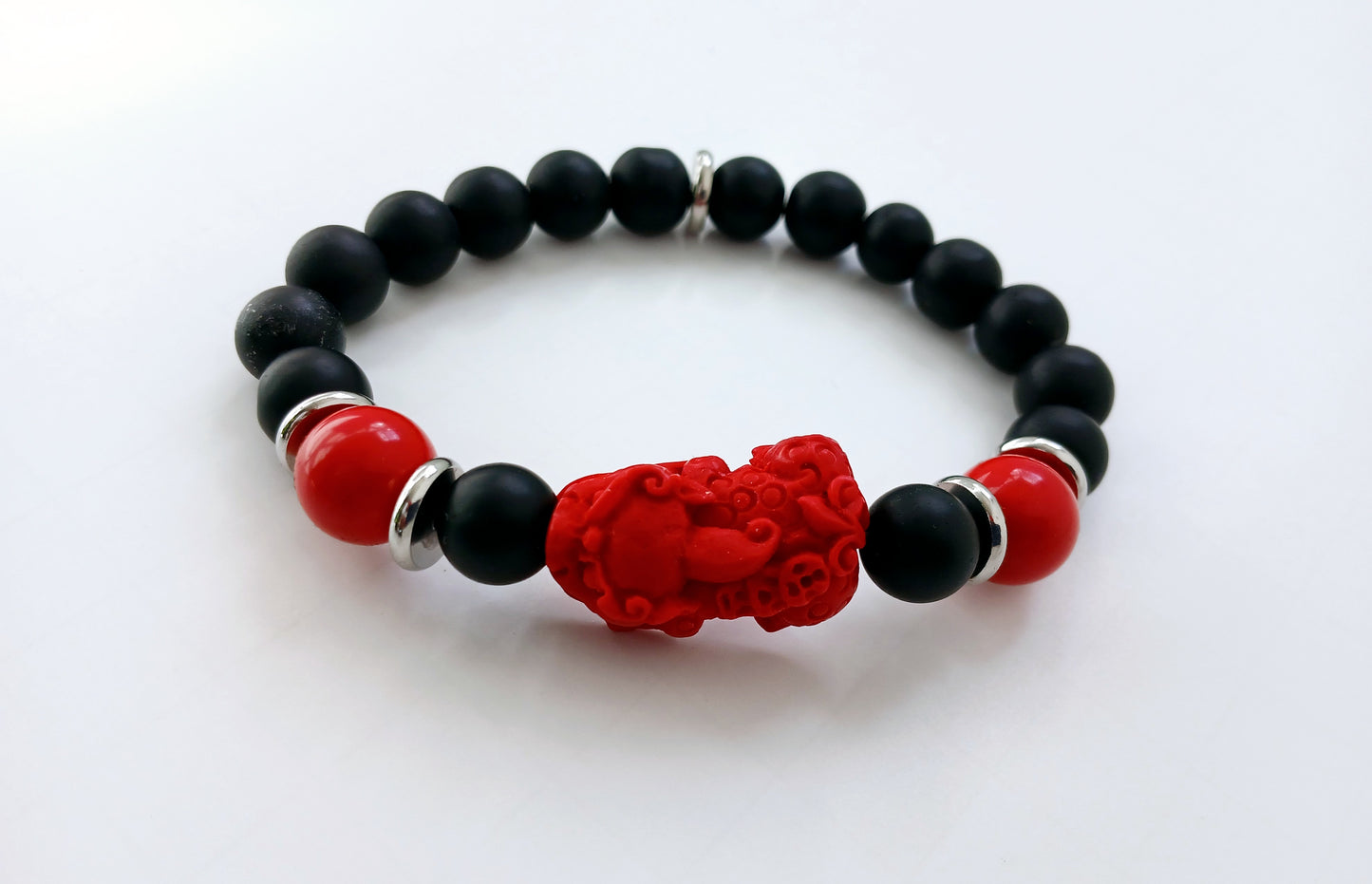 Pixiu Bracelet for men featuring red cinnabar and black onyx beads, designed as a powerful Feng Shui jewelry piece to attract abundance, wealth, and good luck. Inspired by the dragon zodiac, this handmade bracelet symbolizes protection and prosperity. Perfect as a meaningful gift for him, it combines spiritual energy with stylish craftsmanship. Ideal for daily wear or special occasions, enhancing confidence and positive vibes.