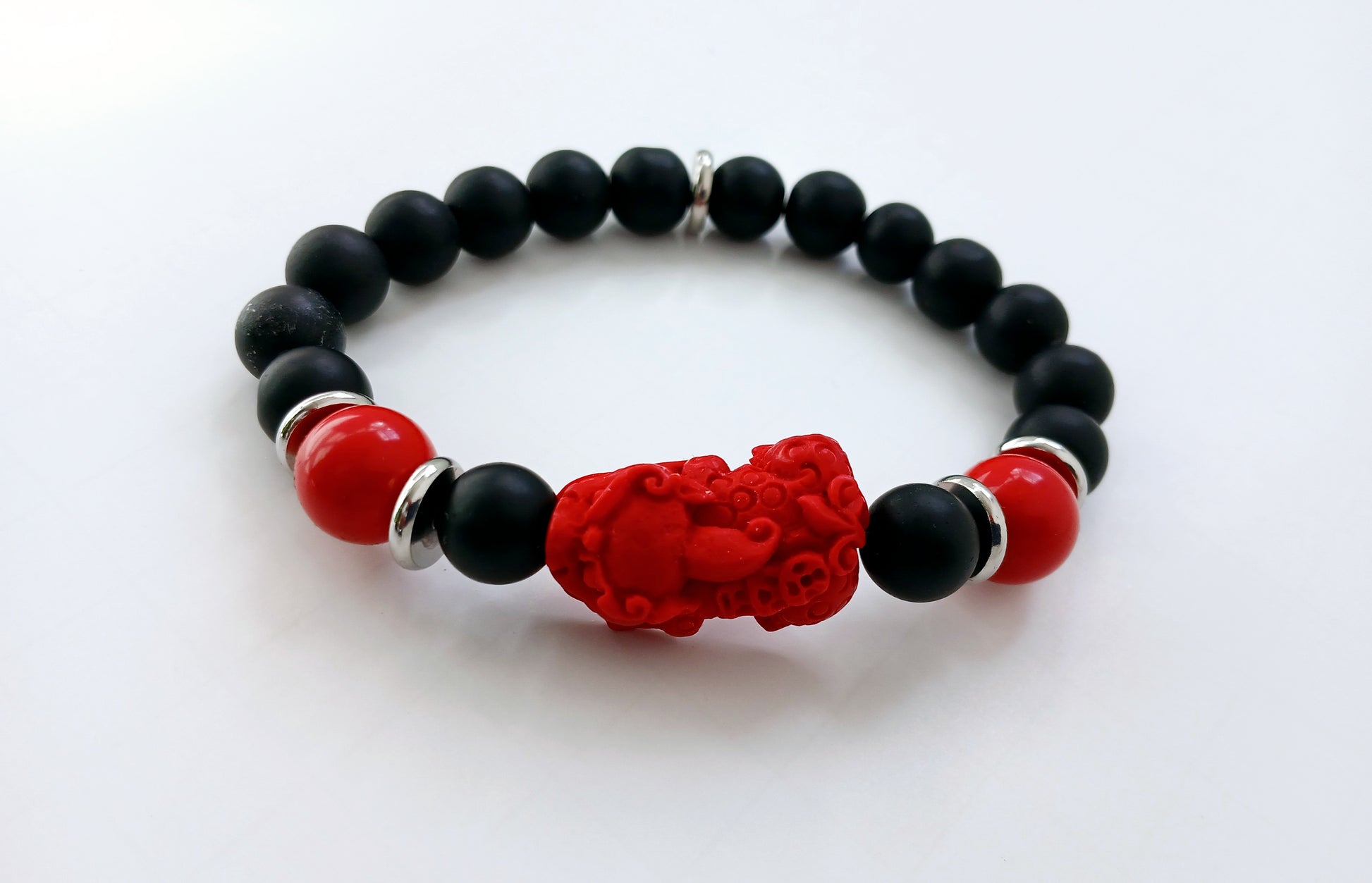 Pixiu Bracelet for men featuring red cinnabar and black onyx beads, designed as a powerful Feng Shui jewelry piece to attract abundance, wealth, and good luck. Inspired by the dragon zodiac, this handmade bracelet symbolizes protection and prosperity. Perfect as a meaningful gift for him, it combines spiritual energy with stylish craftsmanship. Ideal for daily wear or special occasions, enhancing confidence and positive vibes.