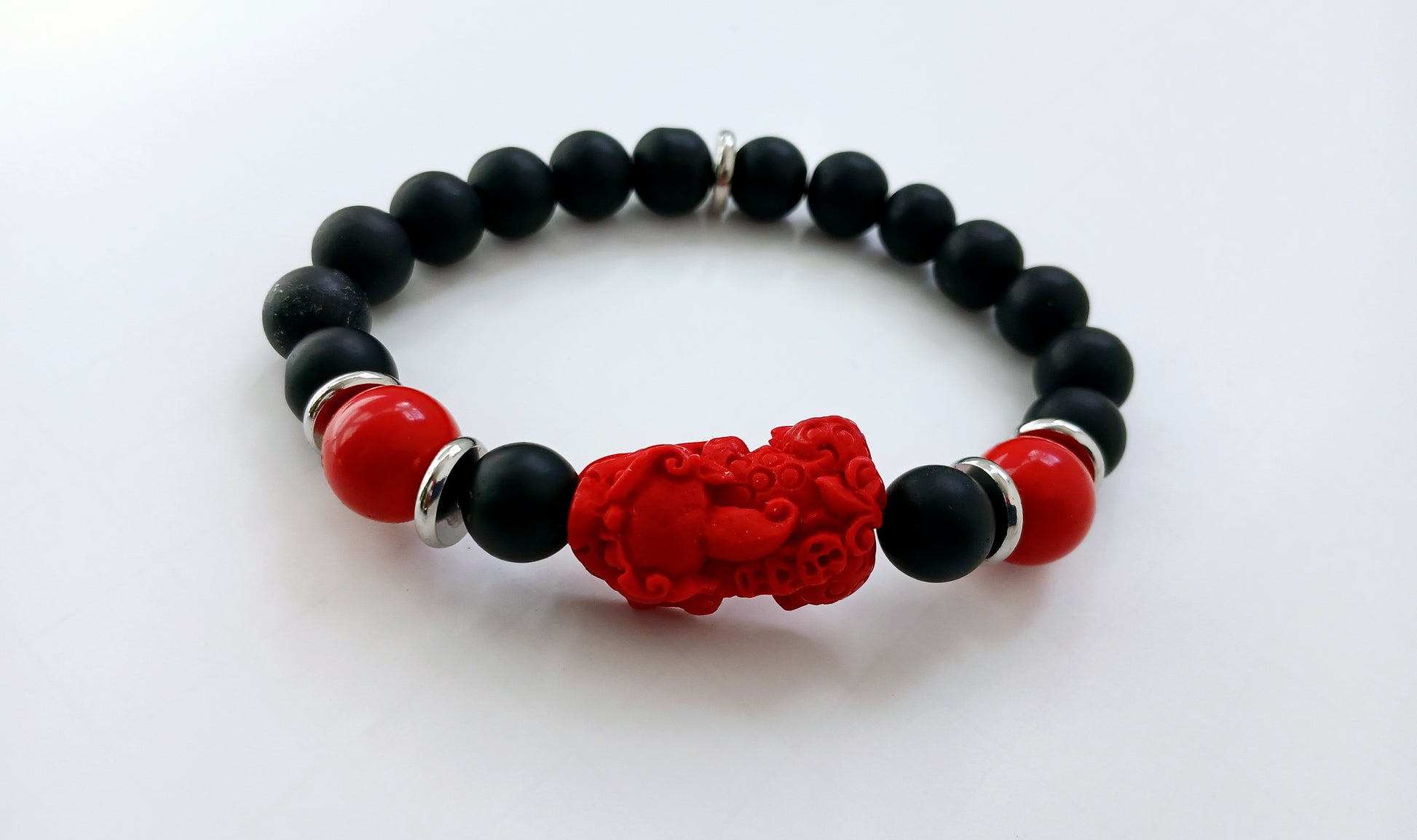 Pixiu Bracelet for men featuring red cinnabar and black onyx beads, designed as a powerful Feng Shui jewelry piece to attract abundance, wealth, and good luck. Inspired by the dragon zodiac, this handmade bracelet symbolizes protection and prosperity. Perfect as a meaningful gift for him, it combines spiritual energy with stylish craftsmanship. Ideal for daily wear or special occasions, enhancing confidence and positive vibes.
