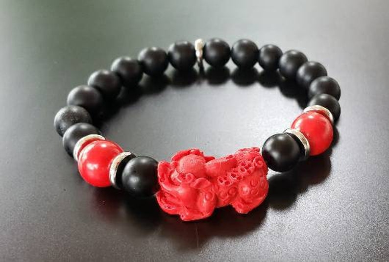 Pixiu Bracelet for men featuring red cinnabar and black onyx beads, designed as a powerful Feng Shui jewelry piece to attract abundance, wealth, and good luck. Inspired by the dragon zodiac, this handmade bracelet symbolizes protection and prosperity. Perfect as a meaningful gift for him, it combines spiritual energy with stylish craftsmanship. Ideal for daily wear or special occasions, enhancing confidence and positive vibes.