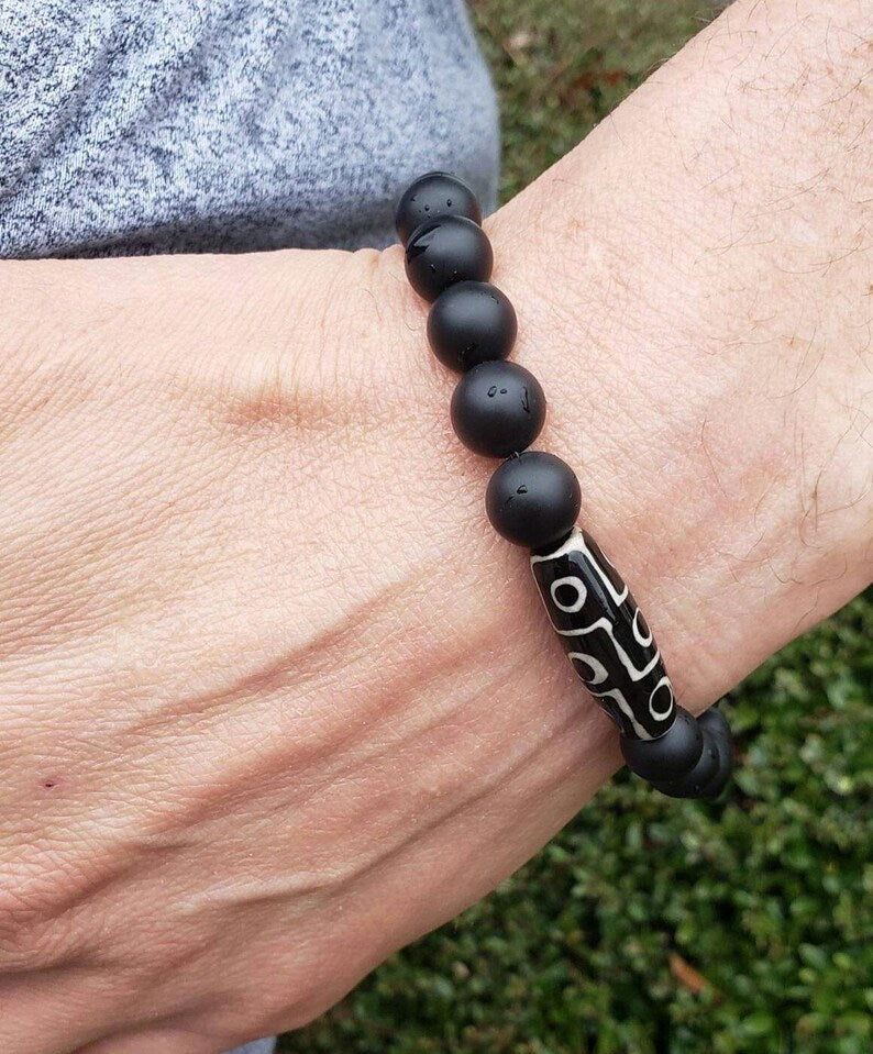 Black Onyx Bracelet with Tibetan Agate accents featuring 10mm stretch beads designed for men who appreciate spiritual healing and stylish jewelry. This handcrafted bracelet combines powerful black onyx stones with earthy agate for balance, protection, and grounding energy. Ideal as a meaningful gift for him, it blends durability and comfort with a sleek, masculine design—perfect for everyday wear, meditation, or enhancing personal style with natural healing properties.