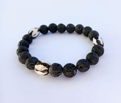 Tibetan Bone Bracelet with 12mm black lava stone beads, designed as a stretch diffuser bracelet for meditation and grounding. This handmade men’s bracelet combines traditional Tibetan jewelry elements with natural lava stones, perfect for essential oils. A meaningful lucky charm and spiritual accessory, ideal for promoting calm and focus. Great handmade gift for him—perfect for yoga, wellness, or daily wear with intention and style.