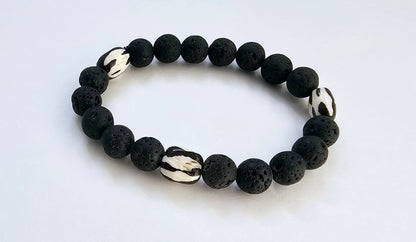 Tibetan Bone Bracelet with 12mm black lava stone beads, designed as a stretch diffuser bracelet for meditation and grounding. This handmade men’s bracelet combines traditional Tibetan jewelry elements with natural lava stones, perfect for essential oils. A meaningful lucky charm and spiritual accessory, ideal for promoting calm and focus. Great handmade gift for him—perfect for yoga, wellness, or daily wear with intention and style.
