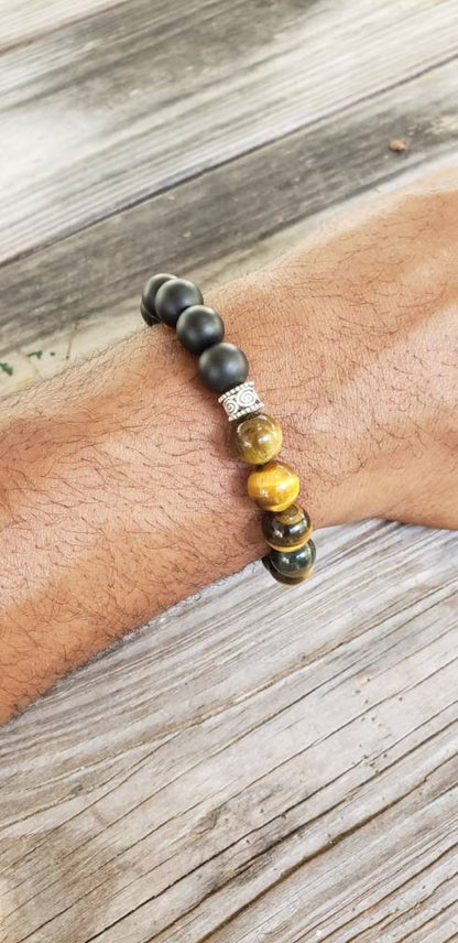 Handmade men’s bracelet featuring natural tiger’s eye and black onyx stones set in a sleek sterling silver bar design. This stylish accessory combines powerful lucky charm stones, known for their protective and grounding properties, making it an ideal birthday gift or meaningful jewelry piece. Perfect for men who appreciate handcrafted, elegant, and masculine jewelry that blends natural elements with modern style.