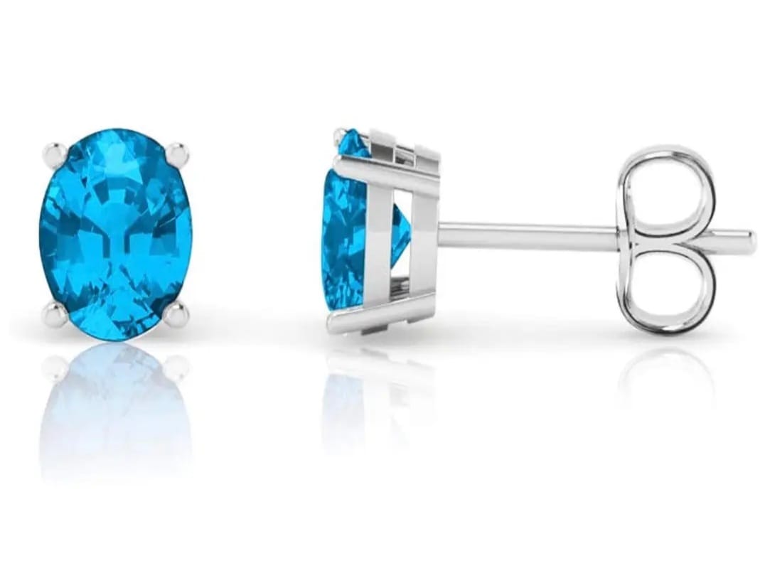 Minimalist Blue Topaz Stud Earrings featuring dainty oval-shaped Swiss blue gemstones set in sterling silver. These elegant birthstone earrings are perfect for women who appreciate subtle, timeless jewelry with a pop of vibrant color. Ideal as a meaningful gift for birthdays or special occasions, they offer a delicate and sophisticated touch to any outfit. Handcrafted with precision, these studs blend classic style with modern simplicity for everyday wear or elegant events.