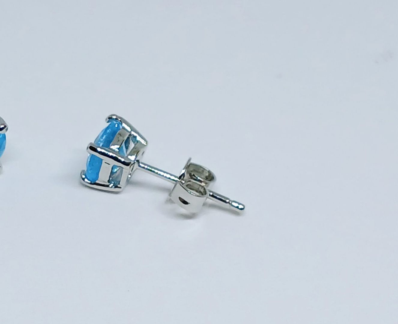Minimalist Blue Topaz Stud Earrings featuring dainty oval-shaped Swiss blue gemstones set in sterling silver. These elegant birthstone earrings are perfect for women who appreciate subtle, timeless jewelry with a pop of vibrant color. Ideal as a meaningful gift for birthdays or special occasions, they offer a delicate and sophisticated touch to any outfit. Handcrafted with precision, these studs blend classic style with modern simplicity for everyday wear or elegant events.