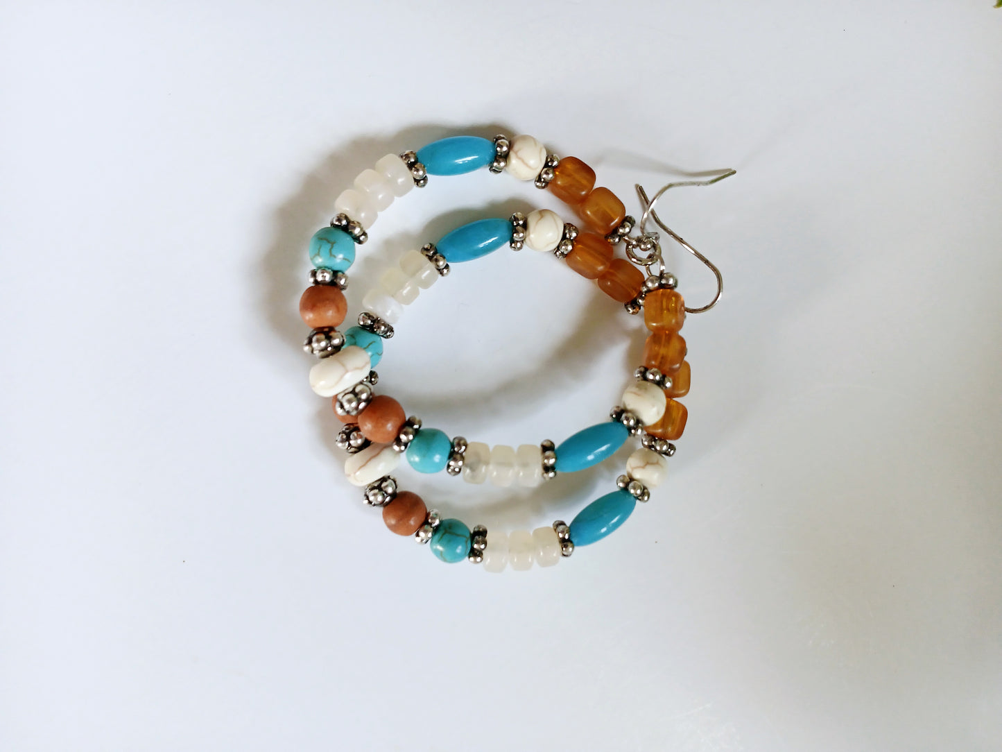 Multi-Color Hoop Earrings featuring vibrant handmade beads arranged in a boho style design, perfect for women who love colorful, trendy jewelry. These lightweight earrings are ideal for festivals, casual outings, or adding a playful touch to any outfit. Crafted with care, they offer comfortable wear and eye-catching appeal, making them a thoughtful gift for her. The bold mix of colors and intricate beadwork create a fun, artistic accessory that celebrates free-spirited, bohemian fashion.