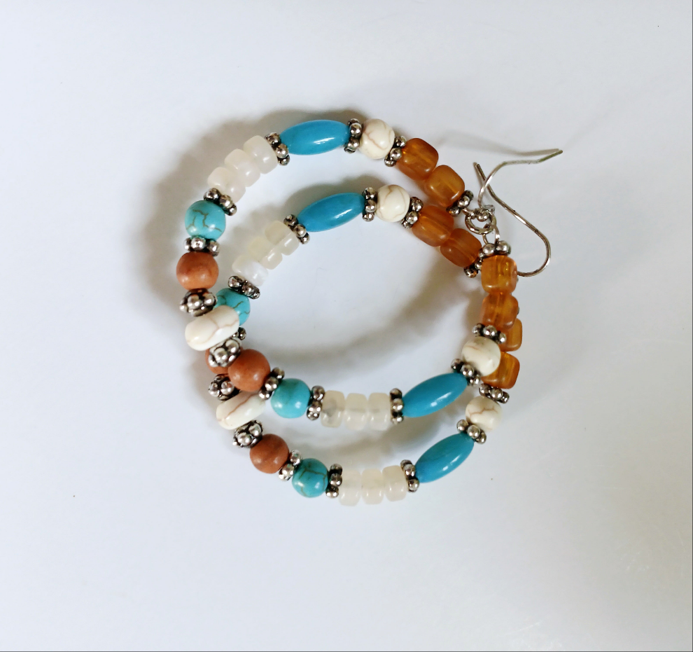 Multi-Color Hoop Earrings featuring vibrant handmade beads arranged in a boho style design, perfect for women who love colorful, trendy jewelry. These lightweight earrings are ideal for festivals, casual outings, or adding a playful touch to any outfit. Crafted with care, they offer comfortable wear and eye-catching appeal, making them a thoughtful gift for her. The bold mix of colors and intricate beadwork create a fun, artistic accessory that celebrates free-spirited, bohemian fashion.
