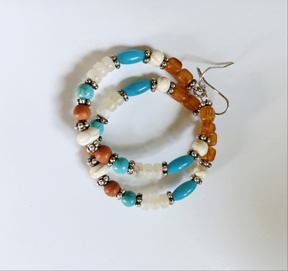 Multi-Color Hoop Earrings featuring vibrant handmade beads arranged in a boho style design, perfect for women who love colorful, trendy jewelry. These lightweight earrings are ideal for festivals, casual outings, or adding a playful touch to any outfit. Crafted with care, they offer comfortable wear and eye-catching appeal, making them a thoughtful gift for her. The bold mix of colors and intricate beadwork create a fun, artistic accessory that celebrates free-spirited, bohemian fashion.