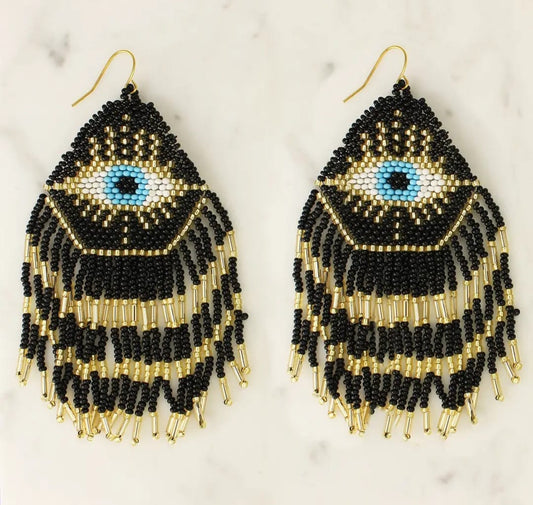 Mystical Eye Seed Bead Fringe Earrings featuring intricate handmade tribal designs with colorful seed bead fringes. These unique boho statement earrings offer bold dangles that capture attention with their vibrant colors and artistic craftsmanship. Perfect for women who love expressive, culturally inspired jewelry, they make an ideal gift for festivals, special occasions, or everyday wear. Lightweight and eye-catching, these earrings add a free-spirited, mystical touch to any outfit.
