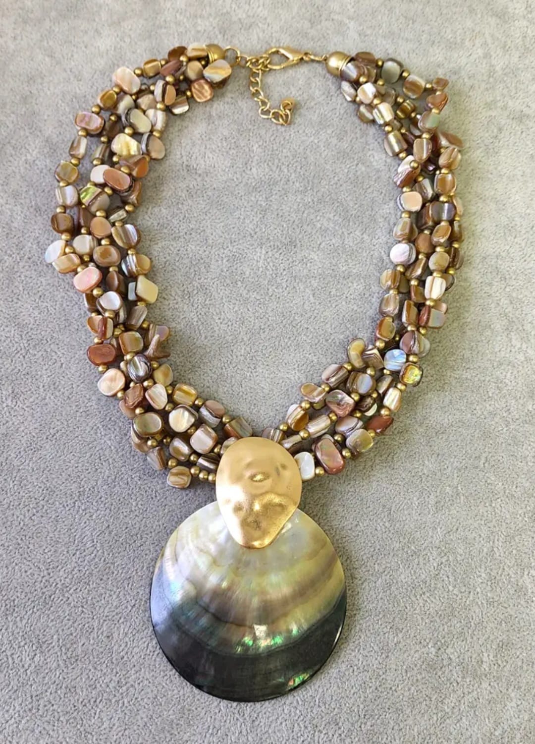 Neutral beige chip abalone pearl seashell pendant necklace featuring a handmade coastal boho design perfect for summer. This beach jewelry piece combines natural abalone chips, pearls, and seashell elements to evoke ocean-inspired elegance. Lightweight and versatile, it complements bohemian style with subtle earthy tones. An ideal gift for her, this necklace captures the serene beauty of the seaside and adds a chic touch to any outfit