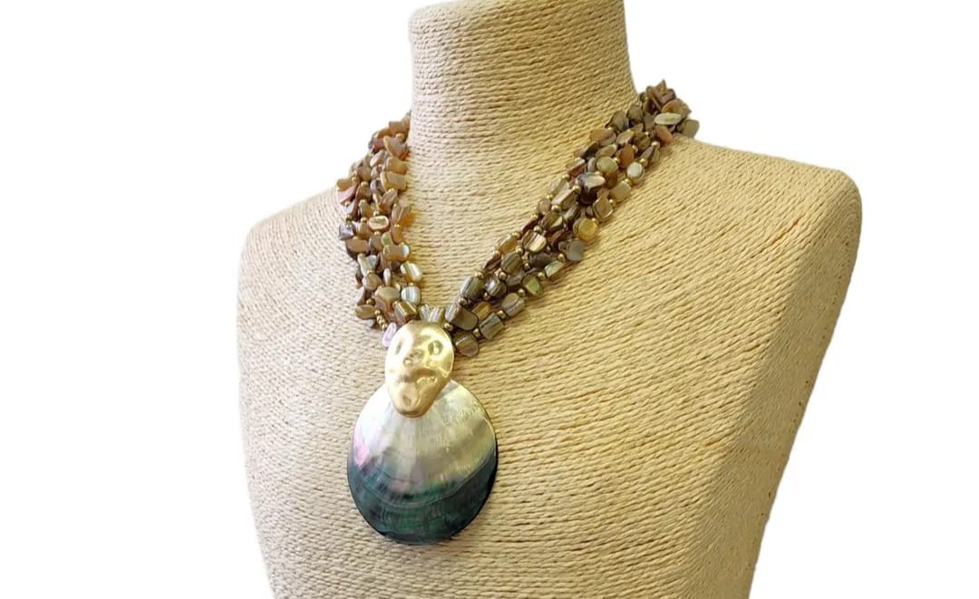 Neutral beige chip abalone pearl seashell pendant necklace featuring a handmade coastal boho design perfect for summer. This beach jewelry piece combines natural abalone chips, pearls, and seashell elements to evoke ocean-inspired elegance. Lightweight and versatile, it complements bohemian style with subtle earthy tones. An ideal gift for her, this necklace captures the serene beauty of the seaside and adds a chic touch to any outfit