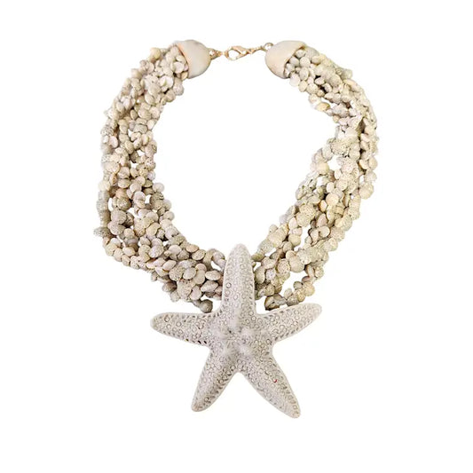Neutral beige layered seashell and starfish pendant necklace featuring a handmade coastal boho design. This beach jewelry piece showcases natural tones and ocean-inspired elements, perfect for summer outfits. Lightweight and versatile, it adds a subtle yet elegant touch to any look. Ideal as a thoughtful gift for her, this necklace captures the serene beauty of the seaside and complements bohemian style with effortless charm.