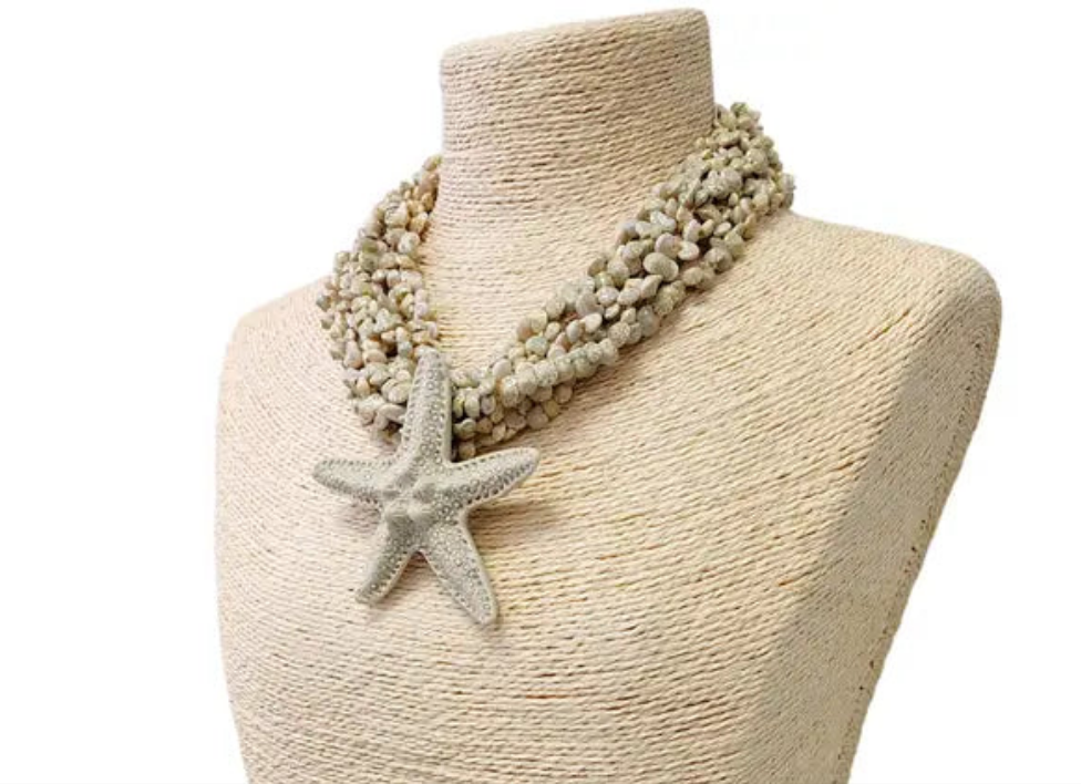 Neutral beige layered seashell and starfish pendant necklace featuring a handmade coastal boho design. This beach jewelry piece showcases natural tones and ocean-inspired elements, perfect for summer outfits. Lightweight and versatile, it adds a subtle yet elegant touch to any look. Ideal as a thoughtful gift for her, this necklace captures the serene beauty of the seaside and complements bohemian style with effortless charm.