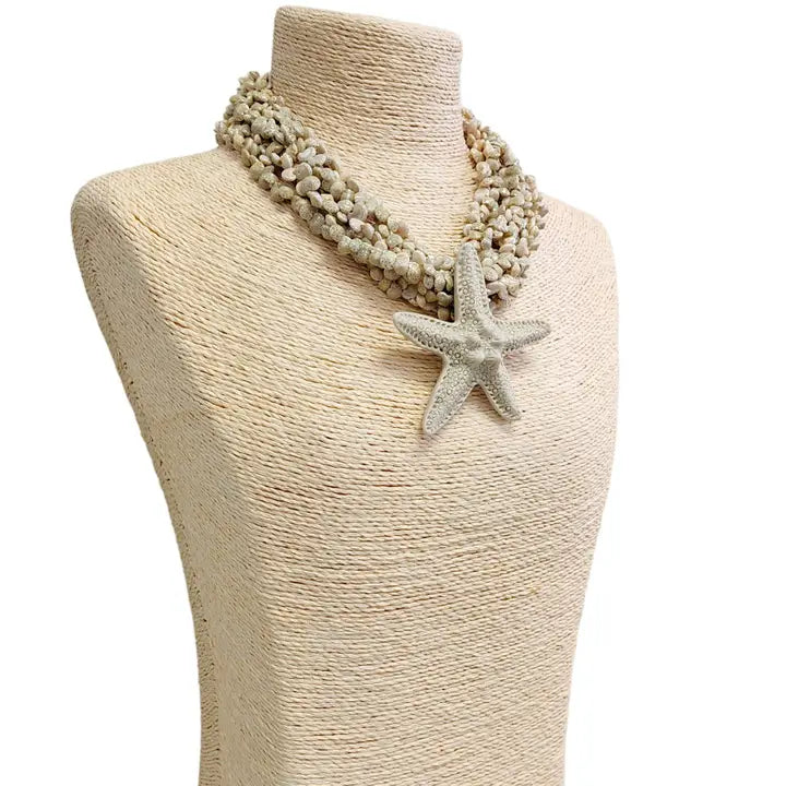 Neutral beige layered seashell and starfish pendant necklace featuring a handmade coastal boho design. This beach jewelry piece showcases natural tones and ocean-inspired elements, perfect for summer outfits. Lightweight and versatile, it adds a subtle yet elegant touch to any look. Ideal as a thoughtful gift for her, this necklace captures the serene beauty of the seaside and complements bohemian style with effortless charm.