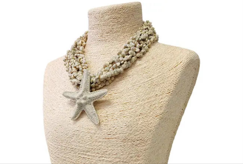 Neutral beige layered seashell and starfish pendant necklace featuring a handmade coastal boho design. This beach jewelry piece showcases natural tones and ocean-inspired elements, perfect for summer outfits. Lightweight and versatile, it adds a subtle yet elegant touch to any look. Ideal as a thoughtful gift for her, this necklace captures the serene beauty of the seaside and complements bohemian style with effortless charm.