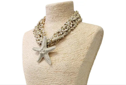 Neutral beige layered seashell and starfish pendant necklace featuring a handmade coastal boho design. This beach jewelry piece showcases natural tones and ocean-inspired elements, perfect for summer outfits. Lightweight and versatile, it adds a subtle yet elegant touch to any look. Ideal as a thoughtful gift for her, this necklace captures the serene beauty of the seaside and complements bohemian style with effortless charm.