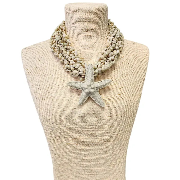 Neutral beige layered seashell and starfish pendant necklace featuring a handmade coastal boho design. This beach jewelry piece showcases natural tones and ocean-inspired elements, perfect for summer outfits. Lightweight and versatile, it adds a subtle yet elegant touch to any look. Ideal as a thoughtful gift for her, this necklace captures the serene beauty of the seaside and complements bohemian style with effortless charm.