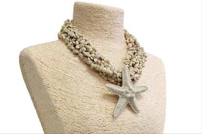 Neutral beige layered seashell and starfish pendant necklace featuring a handmade coastal boho design. This beach jewelry piece showcases natural tones and ocean-inspired elements, perfect for summer outfits. Lightweight and versatile, it adds a subtle yet elegant touch to any look. Ideal as a thoughtful gift for her, this necklace captures the serene beauty of the seaside and complements bohemian style with effortless charm.