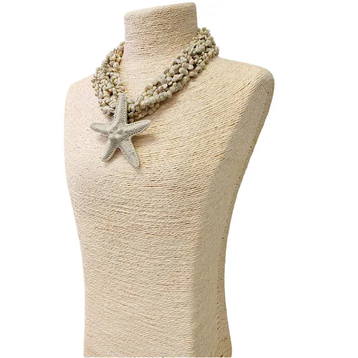 Neutral beige layered seashell and starfish pendant necklace featuring a handmade coastal boho design. This beach jewelry piece showcases natural tones and ocean-inspired elements, perfect for summer outfits. Lightweight and versatile, it adds a subtle yet elegant touch to any look. Ideal as a thoughtful gift for her, this necklace captures the serene beauty of the seaside and complements bohemian style with effortless charm.