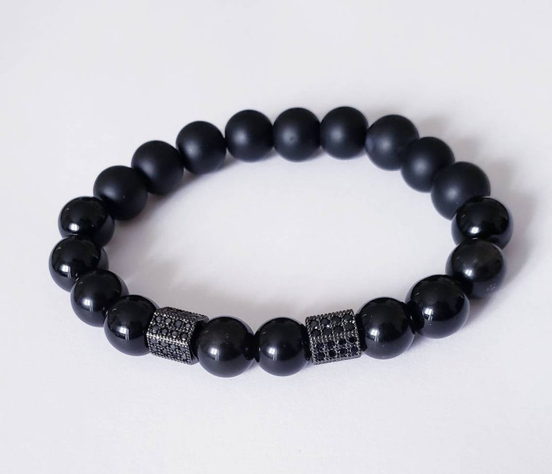 Black Obsidian Onyx Protection Bracelet handmade with natural crystal stones, including Hematite and Lava rock beads. This healing energy bracelet offers grounding and protective properties, perfect for men seeking balance, focus, and emotional strength. Ideal for yoga, meditation, or daily wear, the stylish charm design blends spiritual wellness with fashion. Unique crystal jewelry for men, handcrafted for holistic energy and intention.