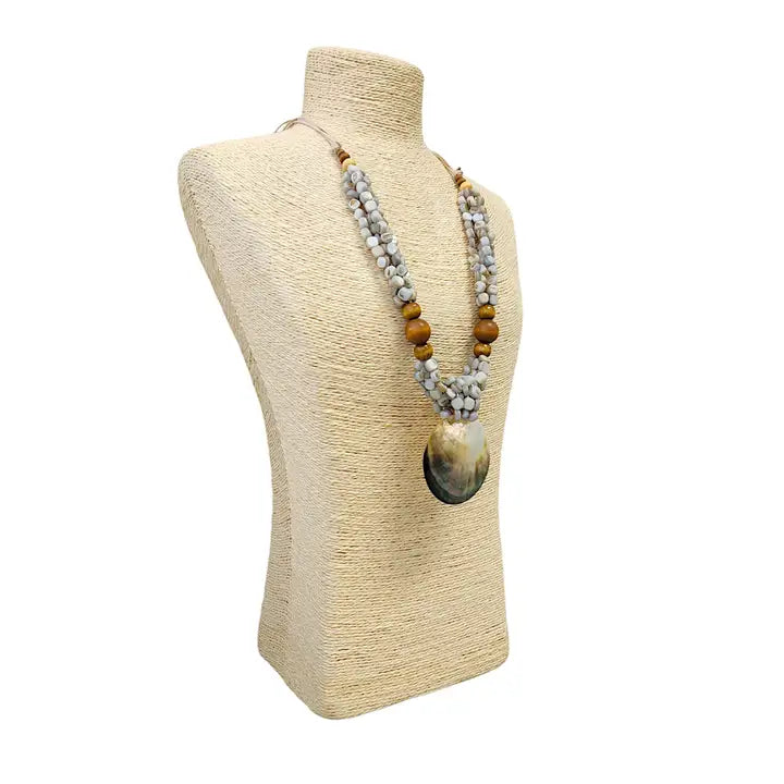 Pastel blue seashell necklace featuring an abalone pendant with natural wood beads, perfect for coastal boho beach style. Inspired by the ocean and mermaid aesthetics, this unique handmade jewelry piece makes a thoughtful gift for sea lovers. Lightweight and easy to wear, it adds a touch of seaside charm to any summer outfit. Ideal for beach vacations, festivals, or casual everyday wear with a nautical, nature-inspired vibe.