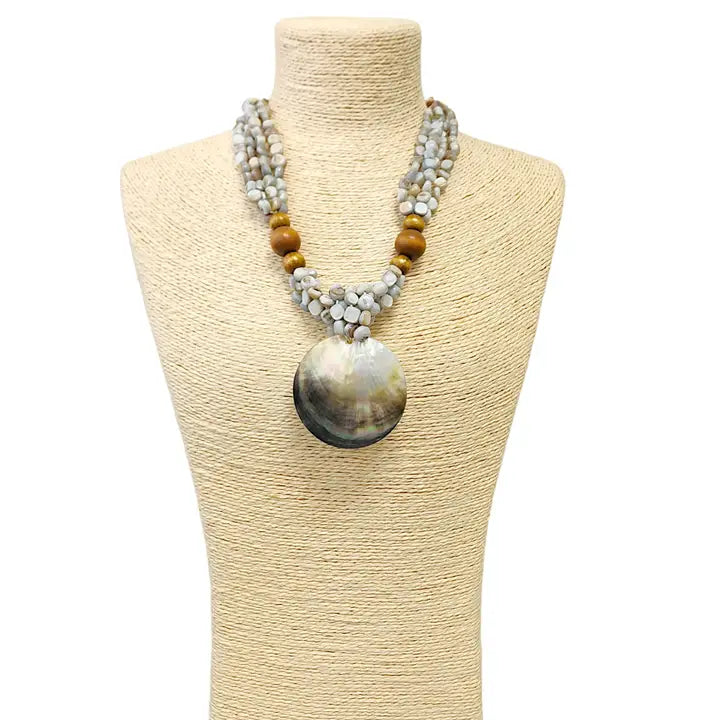 Pastel blue seashell necklace featuring an abalone pendant with natural wood beads, perfect for coastal boho beach style. Inspired by the ocean and mermaid aesthetics, this unique handmade jewelry piece makes a thoughtful gift for sea lovers. Lightweight and easy to wear, it adds a touch of seaside charm to any summer outfit. Ideal for beach vacations, festivals, or casual everyday wear with a nautical, nature-inspired vibe.