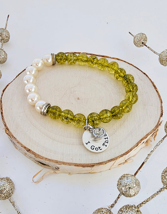 Peridot Cultured Pearl Bracelet with Silver Charm featuring a handmade design that combines the fresh green sparkle of peridot with the soft luster of cultured pearls. This inspirational crystal jewelry piece symbolizes luck, harmony, and positivity, making it a meaningful gift for women. Accented with a delicate silver charm, it’s perfect as a lucky charm bracelet or thoughtful present for birthdays and special occasions, blending elegance, healing energy, and artisanal style.